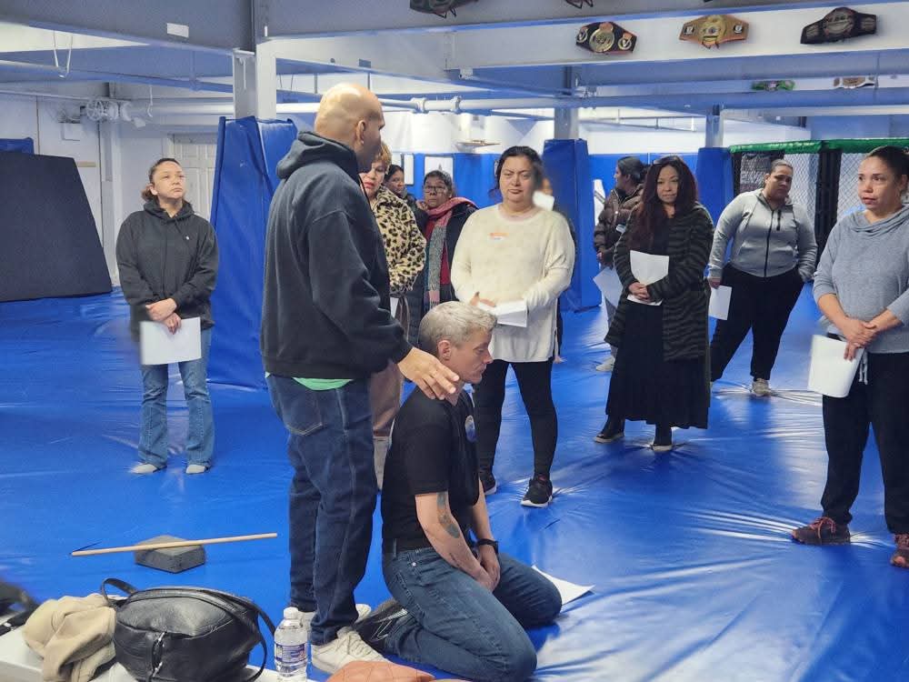 Leonardo Lechuga demonstrating a defensive position while participants watch