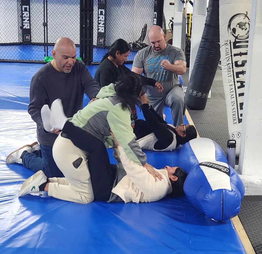 Participants practicing ground defense with instructor guidance