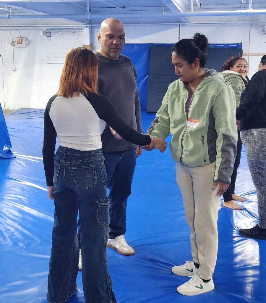 Leonardo Lechuga coaching two participants through a wrist-grab escape